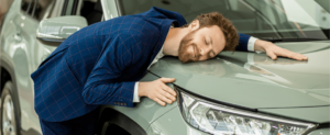 homem abraçando carro, o que é franquia no seguro auto